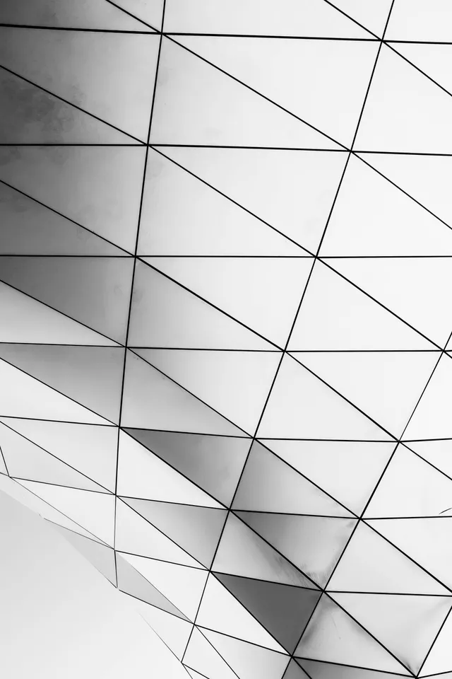 Verglaste Fassadenkonstruktion mit sich kreuzenden Linien als Sinnbild verbundener Systeme
