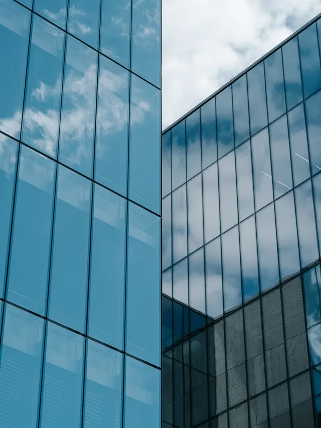 Spiegelnde Glasfassade eines Bürogebäudes als Sinnbild für Betrieb und Skalierung
