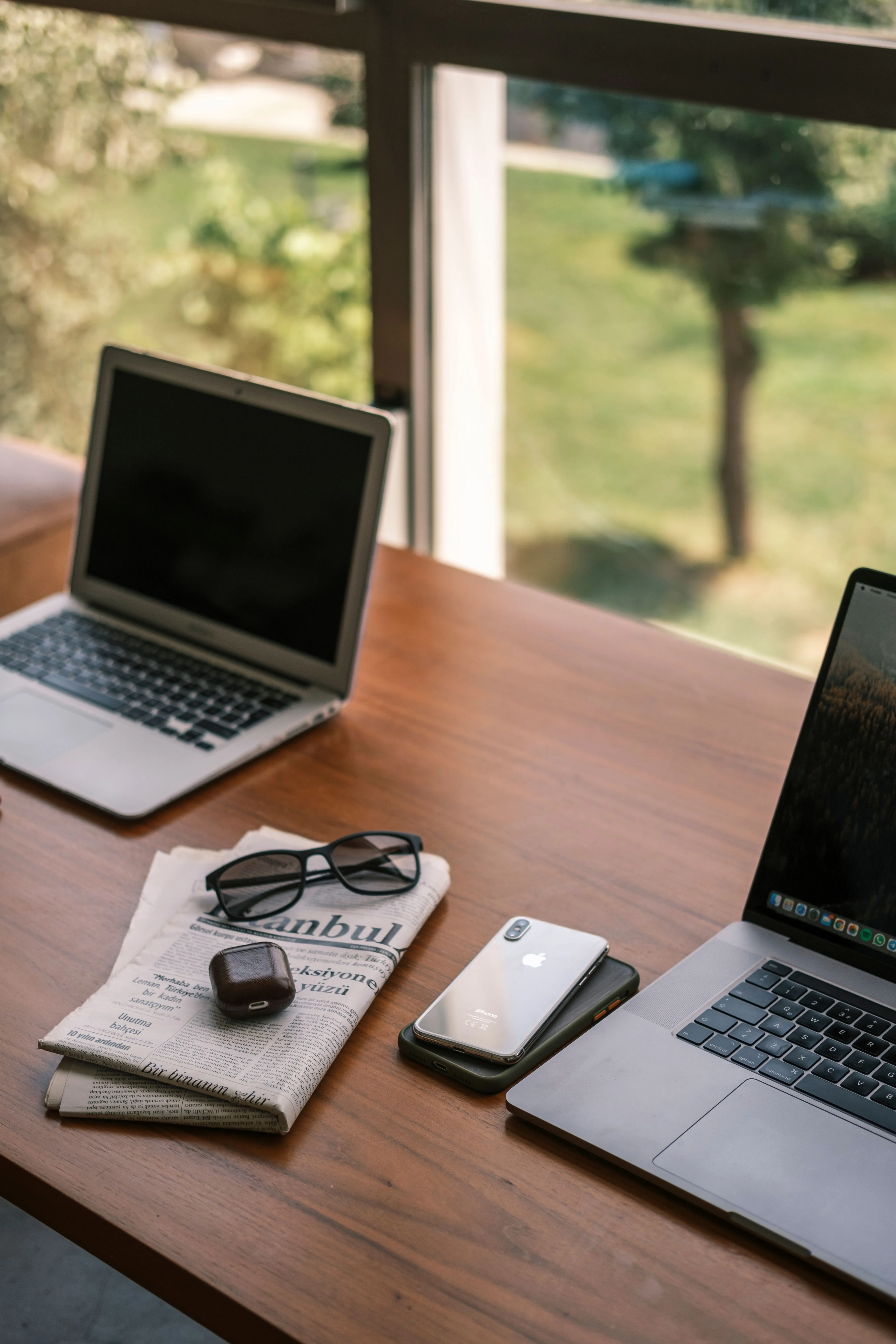 Notebooks und Smartphone auf einem Schreibtisch zuhause am Fenster