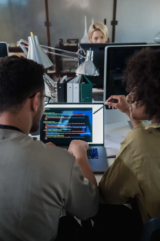Zwei Personen besprechen gemeinsam ein Problem an einem Notebook-Bildschirm